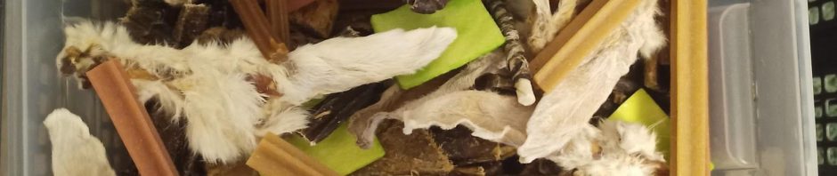 Verschiedene getrocknete Tierteile für Hunde in einer Kiste.