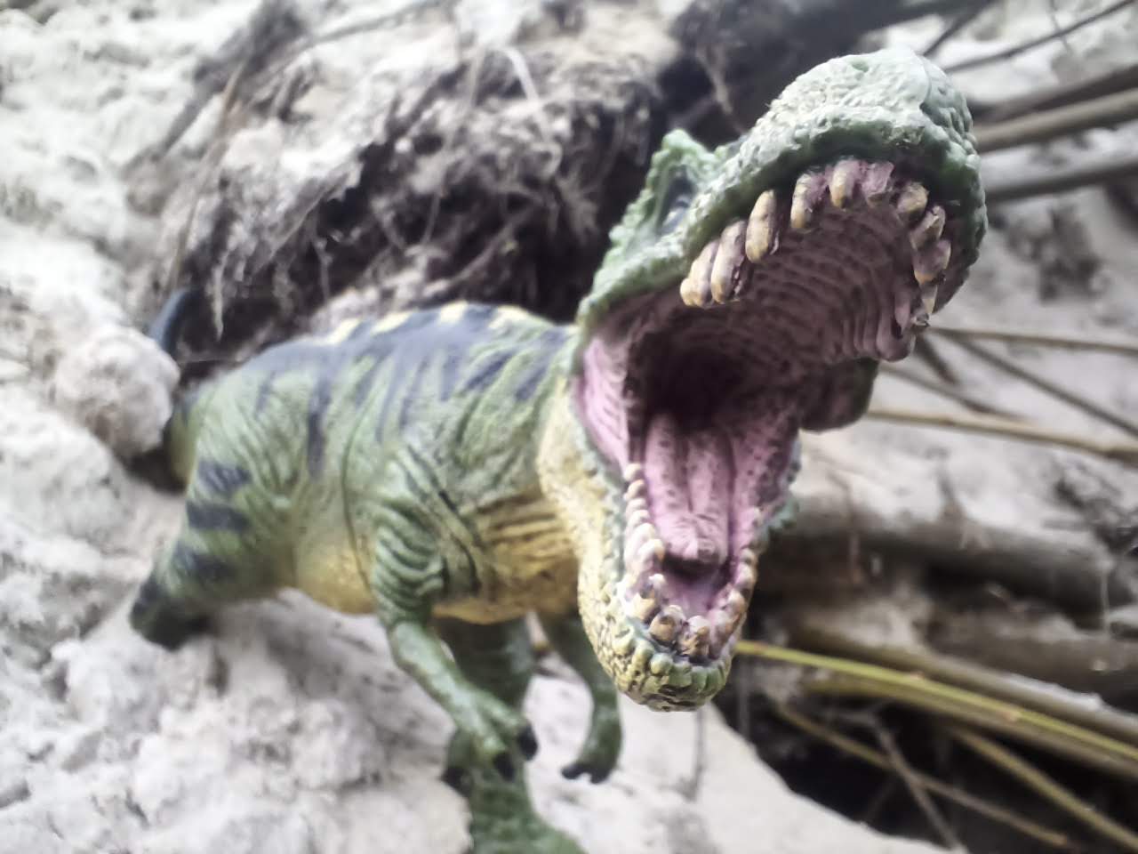 Dinofigur im Sandhügel